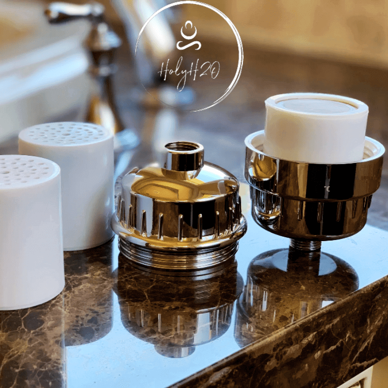 HolyH₂O™ Shower Mate Filter components displayed on a countertop, showcasing chrome and white filter parts.